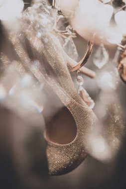 Avize üzerinde asılı beyaz düğün ayakkabıları.