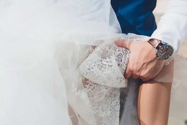 The bride and groom are on the sidewalk, legs close-up. — Stock Photo, Image