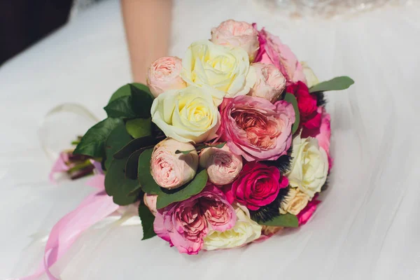 Mooie bruiloft boeket van bloemen in de handen van de bruid. — Stockfoto