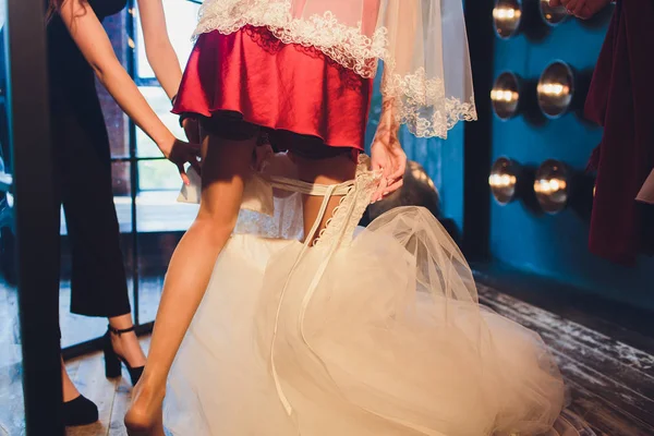 Gorgeous, bruid in witte luxe jurk is het krijgen van klaar voor bruiloft. Ochtend preparaten. Vrouw zetten jurk. — Stockfoto