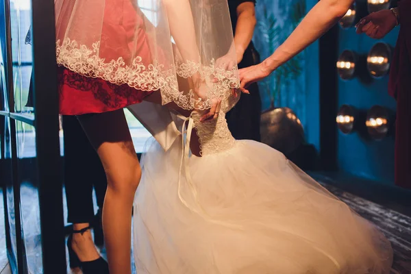 Precioso, novia en vestido de lujo blanco se está preparando para la boda. Preparativos matutinos. Mujer vistiéndose . —  Fotos de Stock