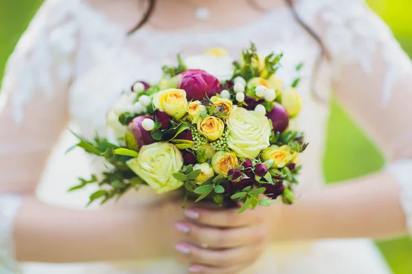 Όμορφο γαμήλιο μπουκέτο από λουλούδια στα χέρια της νύφης. — Φωτογραφία Αρχείου