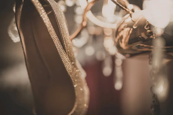 Vitt bröllop skor hänger på ljuskrona. — Stockfoto