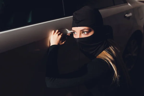 Roubador mascarado mulher carro O ladrão está alavancando a fechadura na porta carro roubo . — Fotografia de Stock
