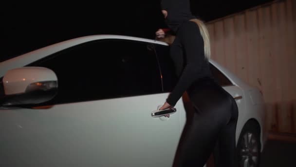 Auto maskované lupiče zloděj používá zámek u dveří na dveřích auta. — Stock video