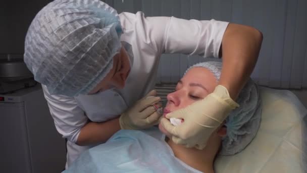 Увеличение губ. Красивая молодая женщина рот получает инъекцию гиалуроновой кислоты. Крупный план косметической процедуры для сексуальных женских губ. Косметологическое лечение. Высокое разрешение . — стоковое видео