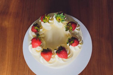 Ahşap arka plan üzerinde tabakta çilek ile Tatlı kek.