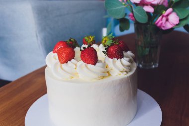 Ahşap arka plan üzerinde tabakta çilek ile Tatlı kek.