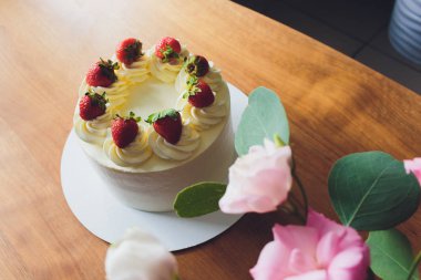 Ahşap arka plan üzerinde tabakta çilek ile Tatlı kek.