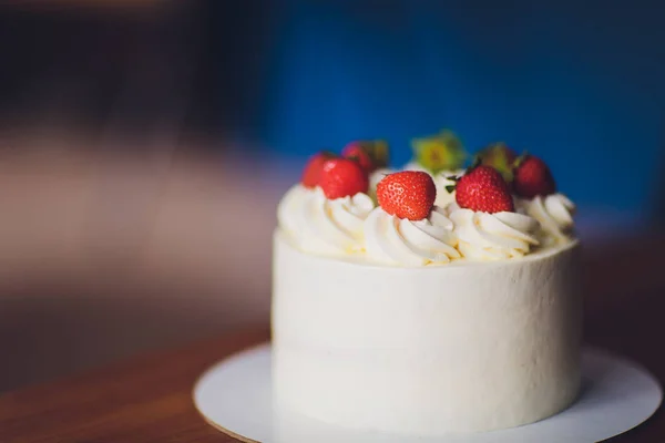 Γλυκό κέικ με φράουλες στο πιάτο σε ξύλινο φόντο. — Φωτογραφία Αρχείου
