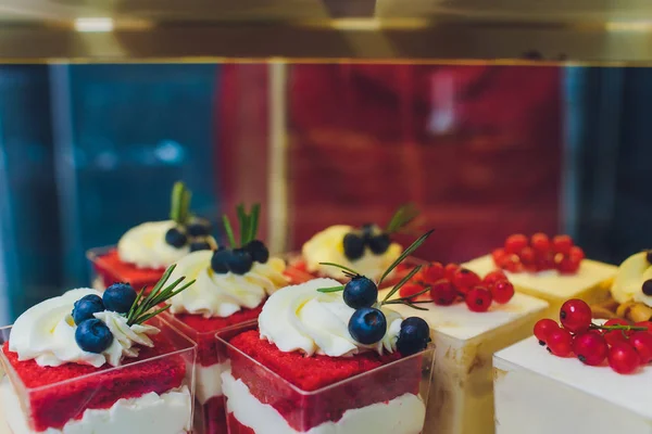 Primer plano de los vendedores manos sacando pastel de escaparate en panadería . — Foto de Stock