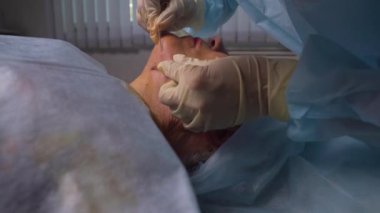 Mezothreads ve Thread Lifting, Kozmetoloji yapıyor yaşlı kadın. Yaşlanma belirtilerini ortadan kaldırmak için kozmetik prosedür. Güzellik Yüz, Yüz kontur, Yaş 70-80 yıl için plastik cerrahi kavramı.