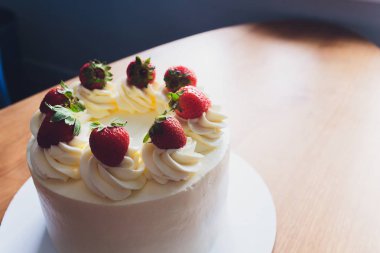 Ahşap arka plan üzerinde tabakta çilek ile Tatlı kek.