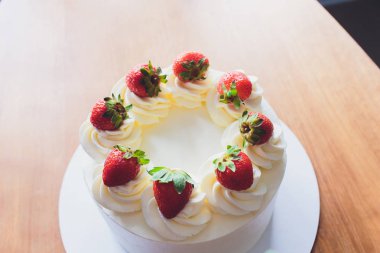 Ahşap arka plan üzerinde tabakta çilek ile Tatlı kek.