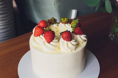 Ahşap arka plan üzerinde tabakta çilek ile Tatlı kek.