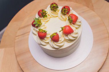 Ahşap arka plan üzerinde tabakta çilek ile Tatlı kek.