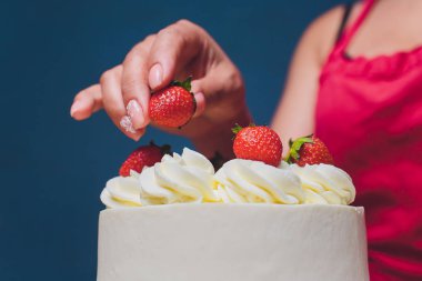 Şekerleme böğürtlen beyaz krema ile bisküvi kek ile dekore edilmiştir. Pasta ahşap bir masanın üzerinde duruyor. Ev yapımı pasta kavramı, pişirme kek.