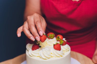 Şekerleme böğürtlen beyaz krema ile bisküvi kek ile dekore edilmiştir. Pasta ahşap bir masanın üzerinde duruyor. Ev yapımı pasta kavramı, pişirme kek.