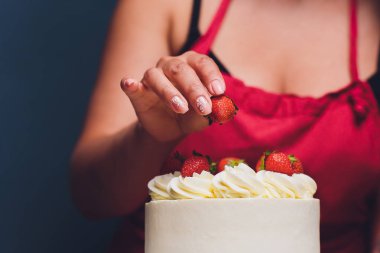 Şekerleme böğürtlen beyaz krema ile bisküvi kek ile dekore edilmiştir. Pasta ahşap bir masanın üzerinde duruyor. Ev yapımı pasta kavramı, pişirme kek.