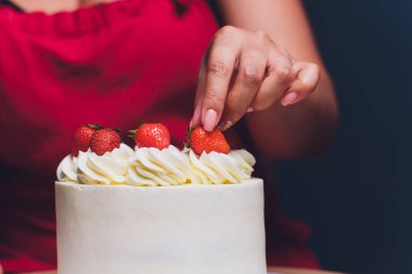 Şekerleme böğürtlen beyaz krema ile bisküvi kek ile dekore edilmiştir. Pasta ahşap bir masanın üzerinde duruyor. Ev yapımı pasta kavramı, pişirme kek.
