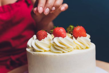 Şekerleme böğürtlen beyaz krema ile bisküvi kek ile dekore edilmiştir. Pasta ahşap bir masanın üzerinde duruyor. Ev yapımı pasta kavramı, pişirme kek.
