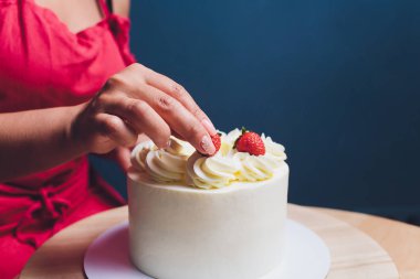 Şekerleme böğürtlen beyaz krema ile bisküvi kek ile dekore edilmiştir. Pasta ahşap bir masanın üzerinde duruyor. Ev yapımı pasta kavramı, pişirme kek.