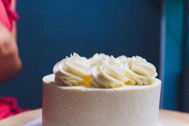 Şekerleme böğürtlen beyaz krema ile bisküvi kek ile dekore edilmiştir. Pasta ahşap bir masanın üzerinde duruyor. Ev yapımı pasta kavramı, pişirme kek.