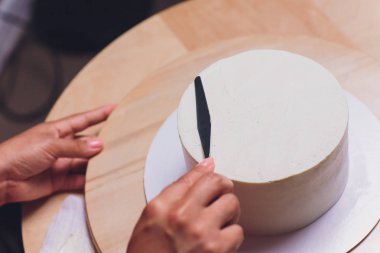 kadın elleri bir pişirme spatula kullanarak beyaz krema ile bisküvi kek yapma.