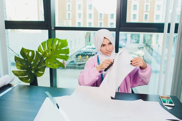 Porträt einer jungen attraktiven muslimischen Modedesignerin in ihrer Werkstatt, die in die Kamera lächelt. — Stockfoto