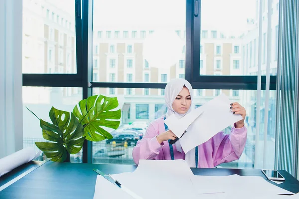 Porträt einer jungen attraktiven muslimischen Modedesignerin in ihrer Werkstatt, die in die Kamera lächelt. — Stockfoto