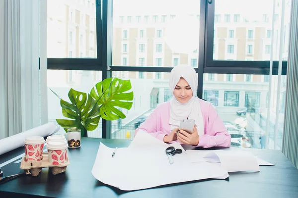 Porträt einer jungen attraktiven muslimischen Modedesignerin in ihrer Werkstatt, die in die Kamera lächelt. — Stockfoto