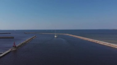 Yat Kulübü ve Marina 'nın insansız hava aracı. Yat kulübünün en iyi manzarası. Deniz suyunda beyaz kayıklar. Marina rıhtımı yatları ve küçük motorlu tekneler. Yat ve yelkenli rıhtıma demirlemiş. Otopark.