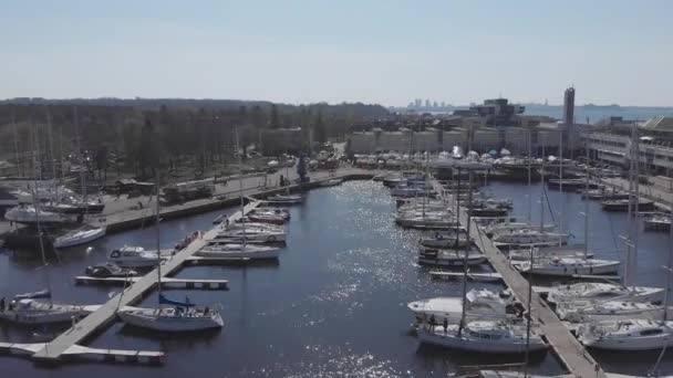 Вид з повітря - Drone of Yacht Club та Marina. Краєвид на яхт-клуб. Білі човни у морській воді. Яхти Marina dock і невеликі моторні човни. Яхт і вітрильник пришвартовані на набережній. Стоянка. — стокове відео