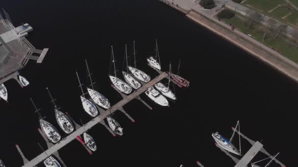 Vista aérea por Drone de Yacht Club y Marina. Vista superior del club náutico. Barcos blancos en agua de mar. Marina muelle de yates y pequeñas lanchas a motor. Yate y velero está amarrado en el muelle. Aparcamiento. — Vídeos de Stock