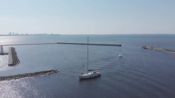 Widok z lotu ptaka przez Drone of Yacht Club i Marina. Widok na klub jachtowy. Białe łodzie w wodzie morskiej. Marina dok jachty i małe łodzie motorowe. Jacht i żaglówka są zacumowane na nabrzeżu. Parking. — Wideo stockowe