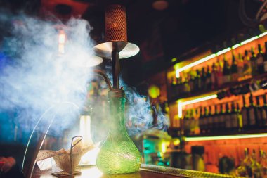 Sigara için nargile yapma süreci. nargile içme ve iyi vakit geçirme kavramı. çubuğun karanlık arka plan üzerinde nargile kase yakın görünümü. Tonlu görüntü.