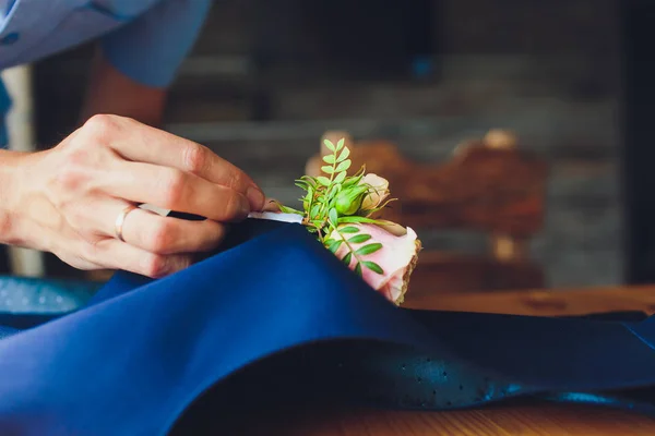 Hand clings till brudgummen en boutonniere av riktiga blommor. — Stockfoto