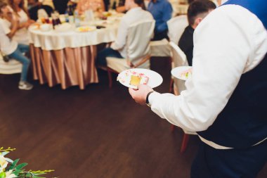 Üç katmanlı beyaz düğün pastası mastik Beyaz ahşap bir masa üzerinde çiçek ile dekore edilmiştir. Bir menü veya bir şekerleme kataloğu ile kopya alanı için resim.