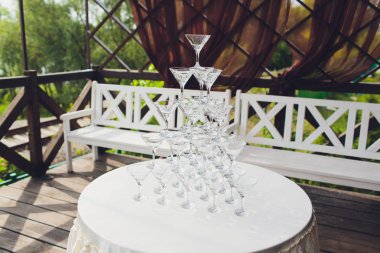 Şampanyalı şarap kadehleri piramidi. Şampanya bardaklara dökülür. Şampanya bardakları bir piramit ile olayın şenlikli dekorasyon. Sıçrama ve damla.