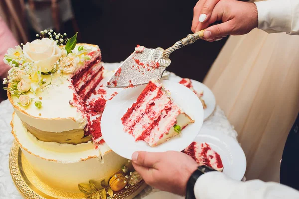 Three-tiered white wedding cake decorated with flowers from mastic on a white wooden table. Picture for a menu or a confectionery catalog with copy space. — Stock Photo, Image