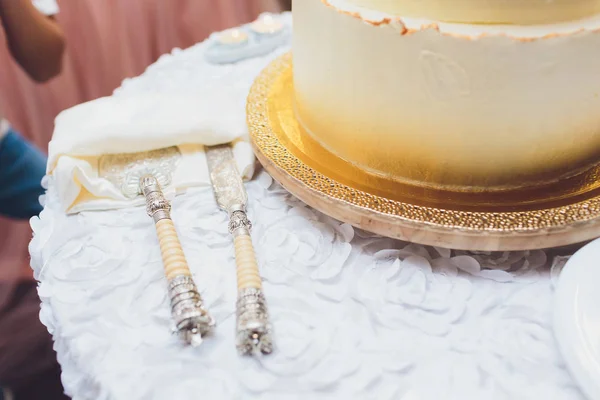 Three-tiered white wedding cake decorated with flowers from mastic on a white wooden table. Picture for a menu or a confectionery catalog with copy space. — Stock Photo, Image