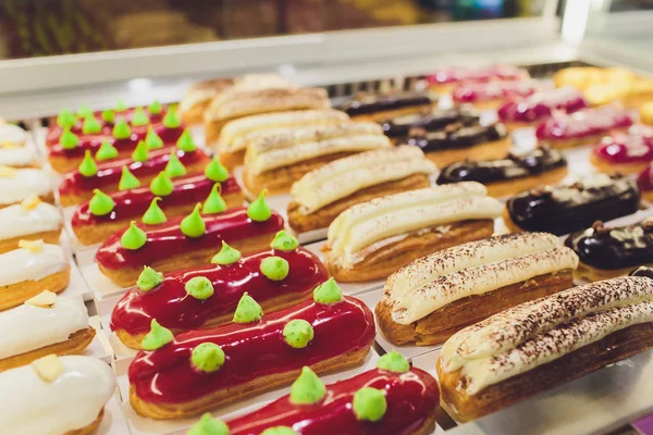 Primer plano de los vendedores manos sacando pastel de escaparate en panadería . — Foto de Stock