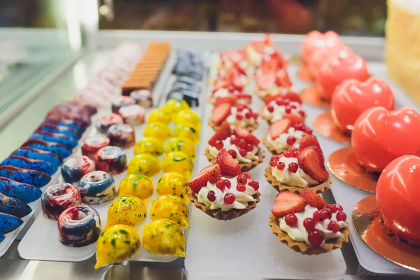 Close up of vendors hands taking out cake from showcase in bakery.