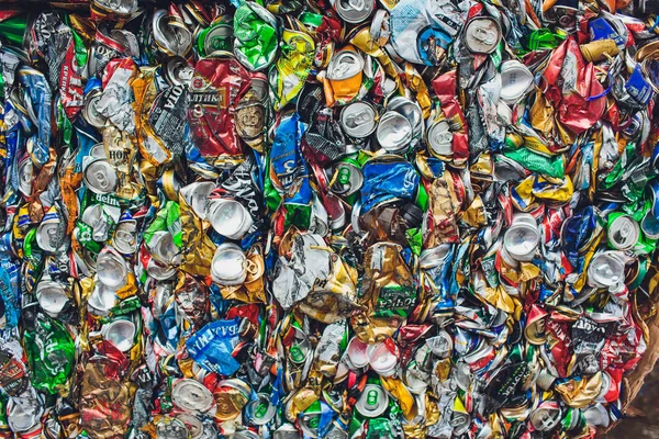 Ufa, Rússia, 1 de julho de 2019: Fechar latas de alumínio comprimido, latas de cerveja, refrigerante triturado na frente do centro da fábrica de reciclagem . — Fotografia de Stock