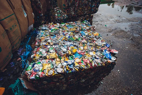 Ufa, Rússia, 1 de julho de 2019: Fechar latas de alumínio comprimido, latas de cerveja, refrigerante triturado na frente do centro da fábrica de reciclagem . — Fotografia de Stock