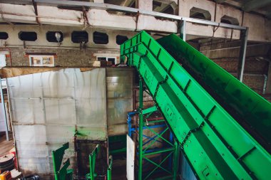 Modern atık geri dönüşüm tesisinde taşıyıcı taşınıyor. Çöp toplama ve ayıklama. Daha fazla atık için geri dönüşüm ve depolama.