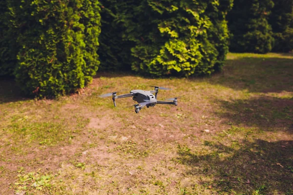 Homme et son drone, quadrocopter dans une forêt sur un fond vert . — Photo