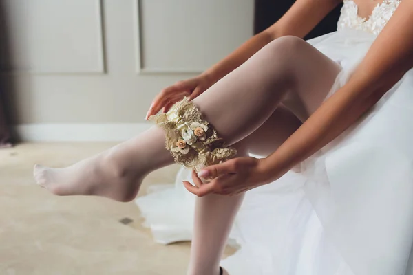 Brud klänningar strumpeband på benet. bild av vackra kvinnliga barfota ben i bröllopsklänning. brud klänningar strumpor på fötterna. bruden att sätta ett bröllop strumpeband på hennes ben. — Stockfoto