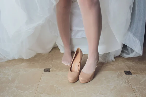 Novia en un hermoso vestido de novia poniéndose zapatos . — Foto de Stock
