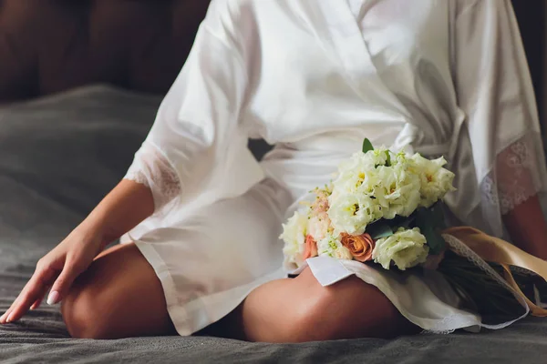 Belo buquê de casamento nas mãos da noiva com rosas. Dia do casamento. Bokeh. Noiva. Buquê de noivas. Flores de casamento. O buquê é decorado com um broche . — Fotografia de Stock